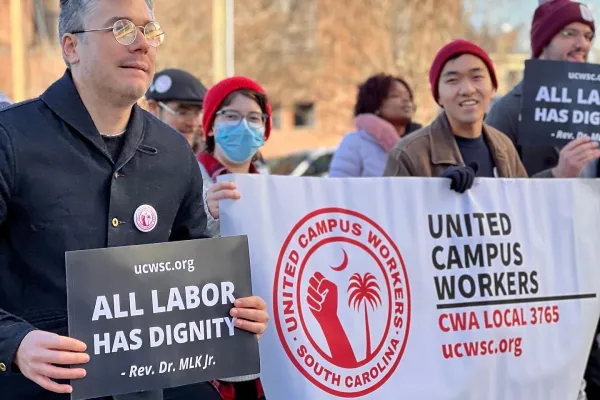 Union members march with sign that says "All labor has dignity" - Rev. Dr. MLK Jr. and banner that reads "United Campus Workers CWA Local 3765"