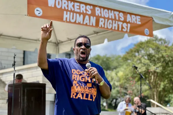 Rep. Wendell Gilliard speaks at ILA Rally in Columbia, S.C. under a banner reading "Worker's Rights Are Human Rights!"